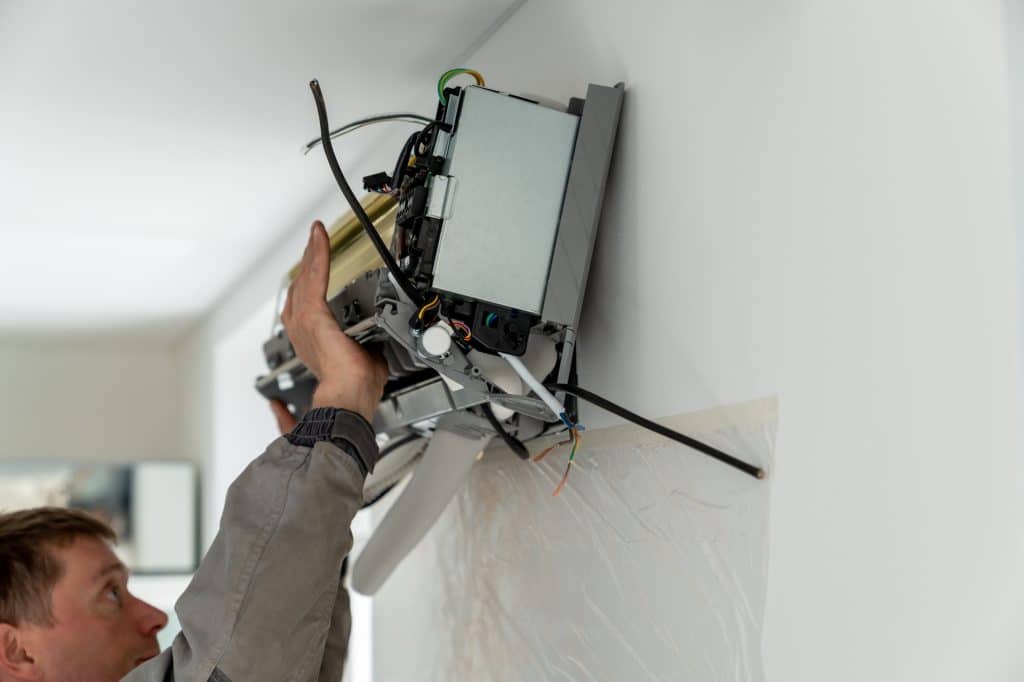 Professional HVAC Installation in Greater Detroit Man technician repairing apartment air conditioner